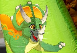 Small bouncer with roof to buy in green and orange color theme with dinosaur. Available at JB Inflatables UK online