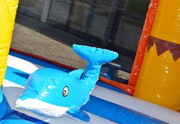 Order a large Indoor beach bounce house with a slide on the jumping surface, climbing tower and fun obstacles beach-themed prints for kids. Buy bounce houses online at JB Inflatables UK