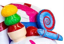 Indoor multiplay candyland bouncy castle in a unique design with two entrances, a slide in the middle and 3D objects for kids. Buy bouncy castles online at JB Inflatables UK