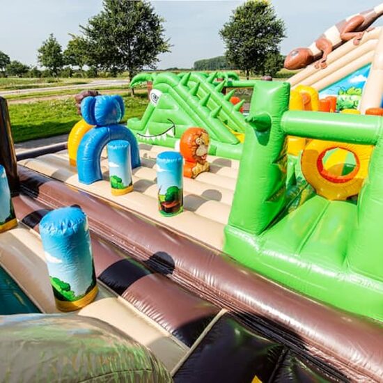 World jungle bouncy castle with multiple slides and all kinds of obstacles with prints that match the theme for kids. Buy bouncy castles online at JB Inflatables UK