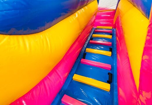 Climbing on bouncy castle in cheerful colors pink, yellow and blue